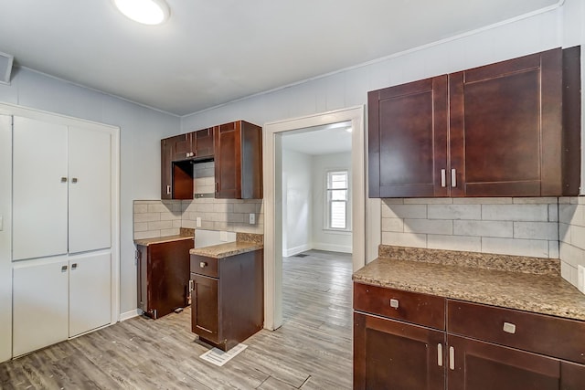 kitchen with backsplash, light hardwood / wood-style flooring, and ornamental molding