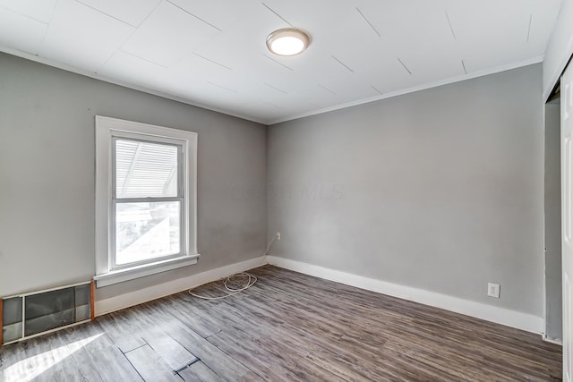 unfurnished room featuring ornamental molding and hardwood / wood-style flooring