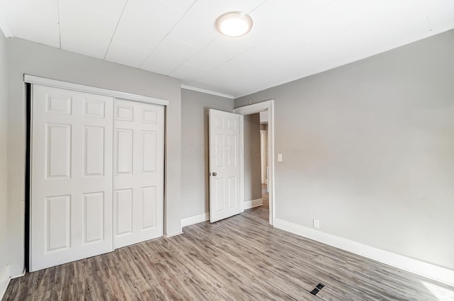 unfurnished bedroom with light wood-type flooring and a closet