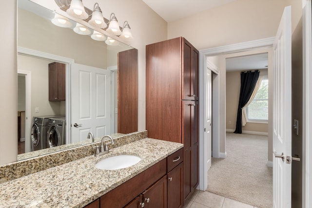 bathroom featuring tile patterned flooring, vanity, and washer and dryer