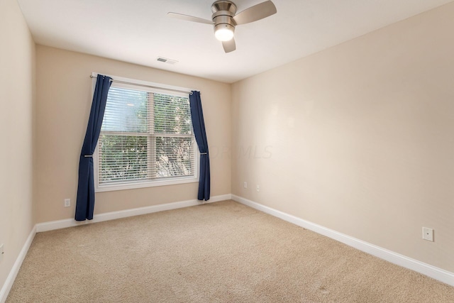 carpeted spare room with ceiling fan