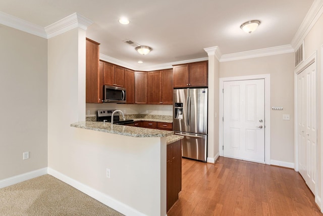 kitchen with stainless steel appliances, light stone counters, light hardwood / wood-style flooring, kitchen peninsula, and ornamental molding