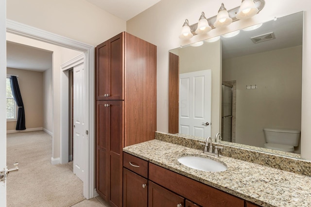 bathroom with a shower, vanity, and toilet