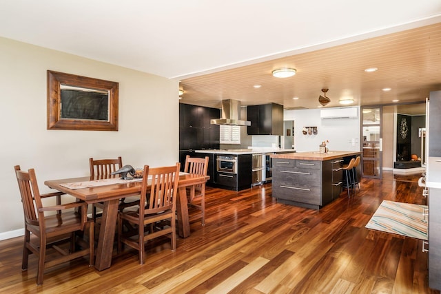 dining space featuring dark wood finished floors, recessed lighting, an AC wall unit, and baseboards