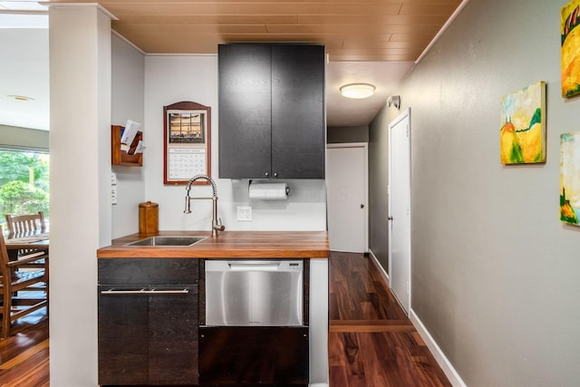 kitchen with a sink, wood counters, baseboards, dishwasher, and dark wood-style flooring