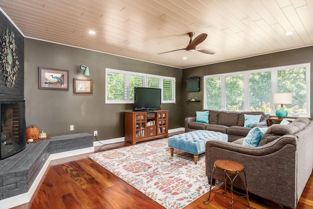 living room with a brick fireplace, wood ceiling, baseboards, and wood finished floors