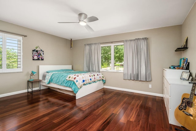 bedroom featuring multiple windows, wood finished floors, and baseboards