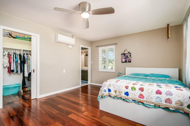 bedroom featuring a wall mounted air conditioner, dark wood finished floors, a closet, baseboards, and ceiling fan