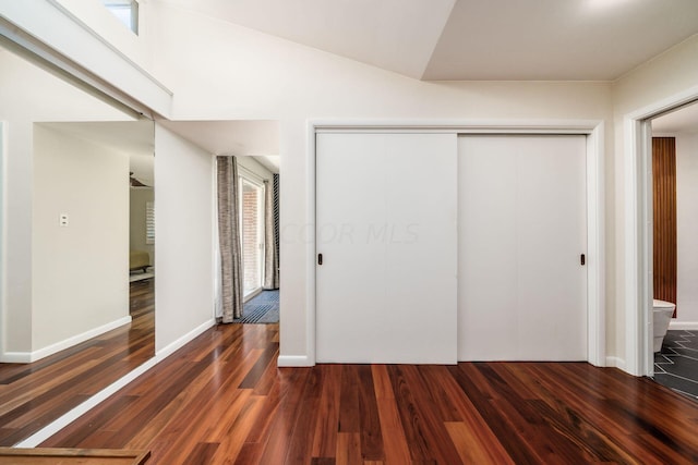 unfurnished bedroom featuring a closet, baseboards, and wood finished floors