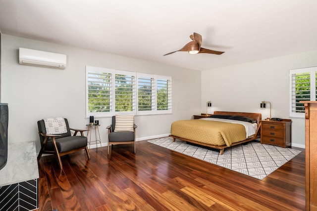 bedroom with ceiling fan, a wall mounted air conditioner, baseboards, and wood finished floors