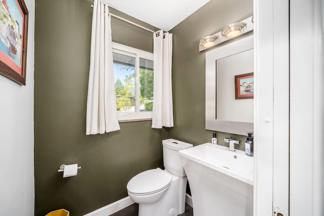 half bathroom with toilet and baseboards