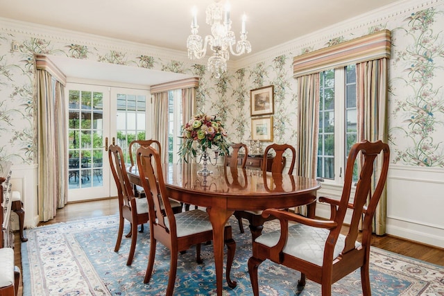 dining space featuring hardwood / wood-style flooring, a healthy amount of sunlight, crown molding, and french doors