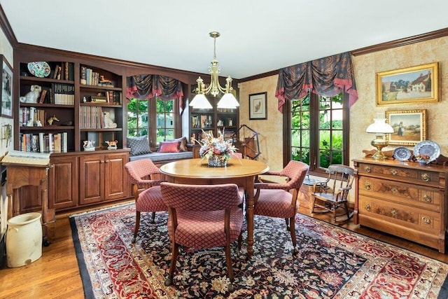 dining area featuring french doors, an inviting chandelier, ornamental molding, and light wood-type flooring