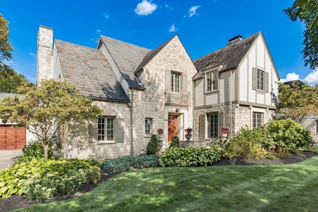 english style home with a front yard