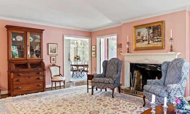 sitting room featuring hardwood / wood-style floors, ornamental molding, and a high end fireplace