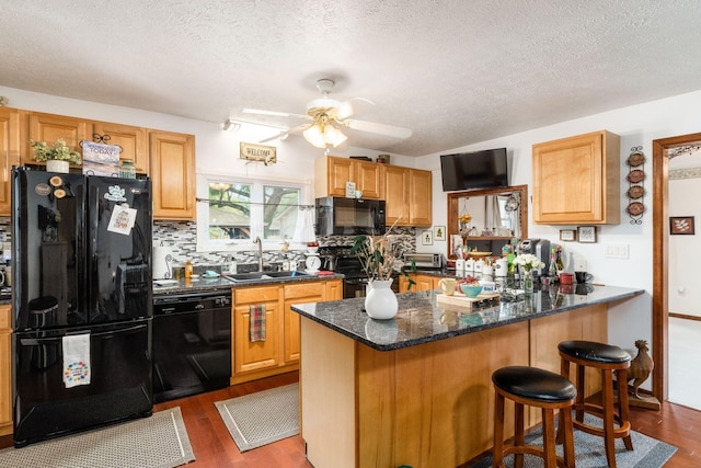 5595 Lancaster Rd, Hebron, OH 43025 - kitchen featuring sink, dark hardwood / wood-style floors, kitchen peninsula, a textured ceiling, and black appliances