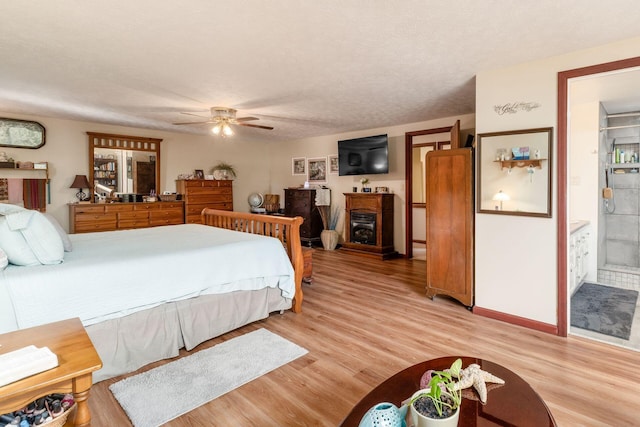 5595 Lancaster Rd, Hebron, OH 43025 - bedroom featuring light wood-type flooring, a textured ceiling, connected bathroom, and ceiling fan