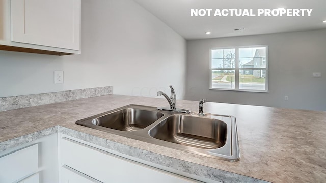 kitchen featuring white cabinets and sink