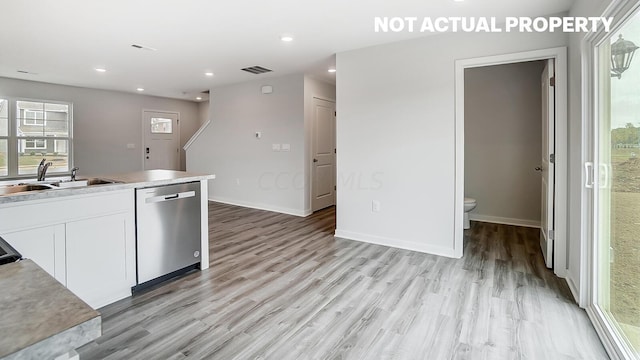 kitchen featuring dishwasher, light hardwood / wood-style flooring, white cabinetry, and sink