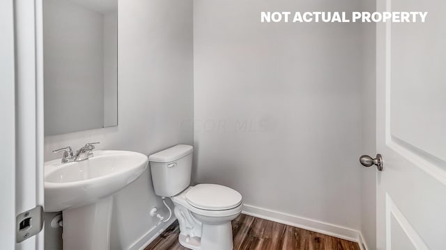 bathroom with wood-type flooring and toilet