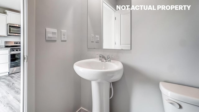 bathroom featuring hardwood / wood-style floors, toilet, and sink