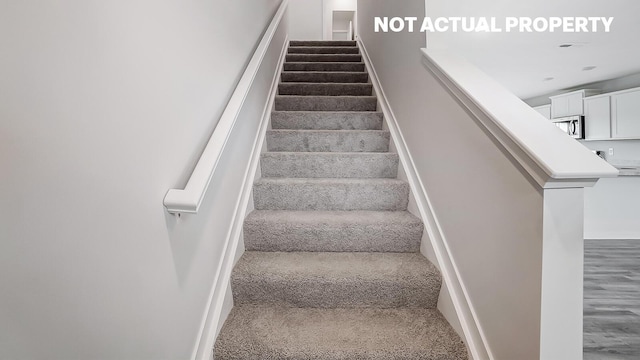 stairs featuring hardwood / wood-style floors