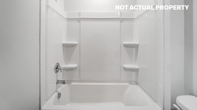 bathroom featuring toilet and bathing tub / shower combination