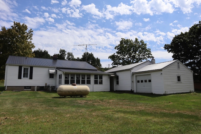 back of house with a lawn and a garage