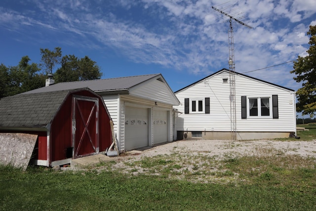 rear view of house with a garage and an outdoor structure