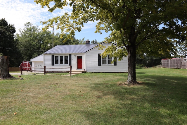 view of front of house featuring a front lawn, an outdoor structure, and a garage