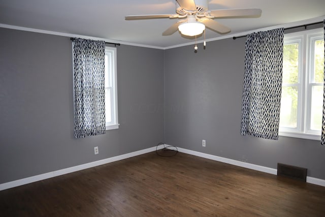 spare room with crown molding, ceiling fan, and dark wood-type flooring