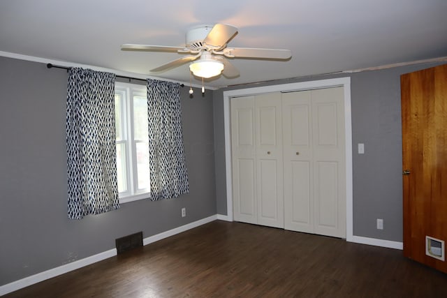 unfurnished bedroom featuring a closet, ceiling fan, dark hardwood / wood-style flooring, and crown molding