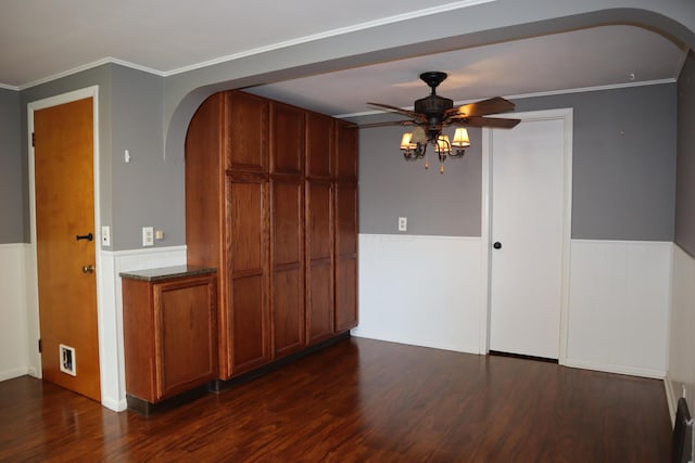 spare room featuring crown molding, ceiling fan, and dark wood-type flooring