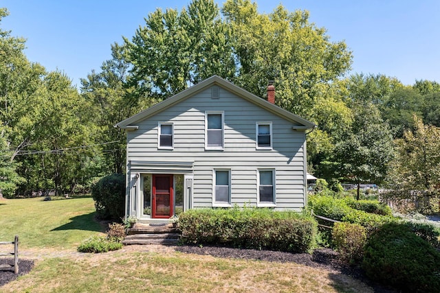 traditional home featuring a chimney and a front yard