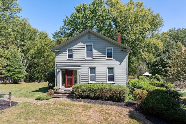 traditional-style home featuring a front yard and a chimney