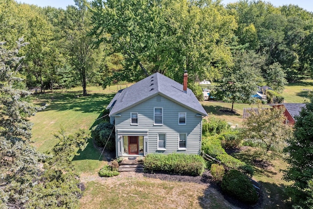 view of front of property featuring a chimney and a front yard