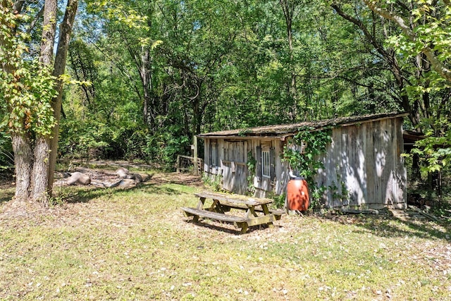 view of yard with a forest view and an outdoor structure