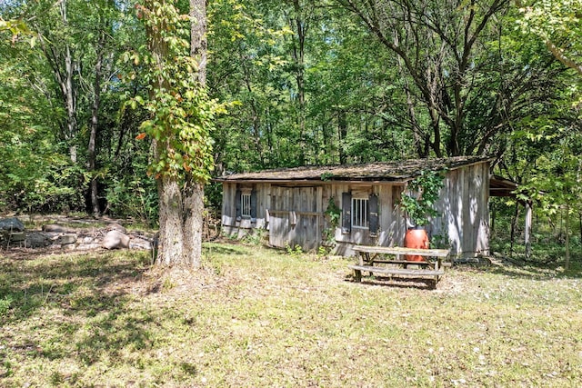 view of yard featuring a view of trees and an outbuilding