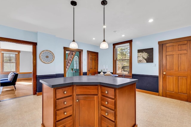 kitchen with dark countertops, light floors, and a kitchen island