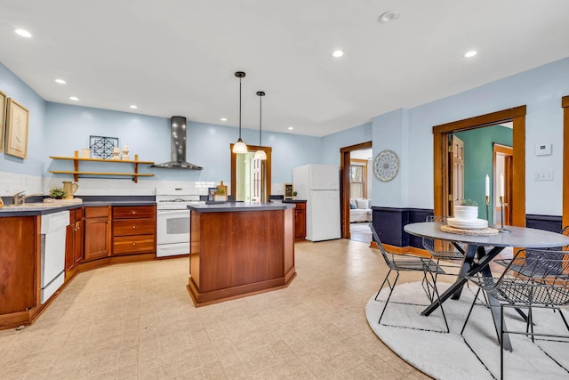 kitchen with a center island, open shelves, dark countertops, white appliances, and wall chimney exhaust hood