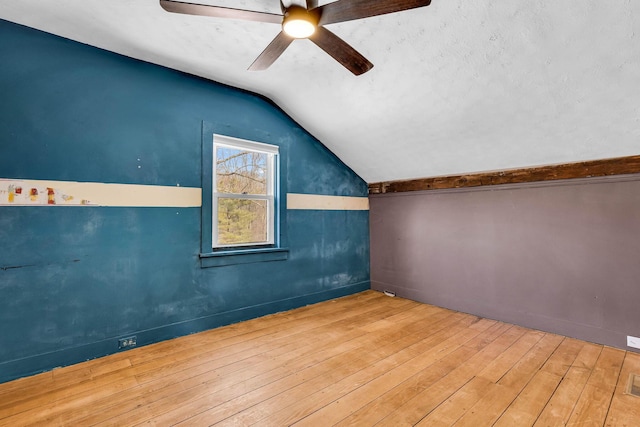 bonus room with visible vents, a ceiling fan, lofted ceiling, hardwood / wood-style flooring, and a textured ceiling