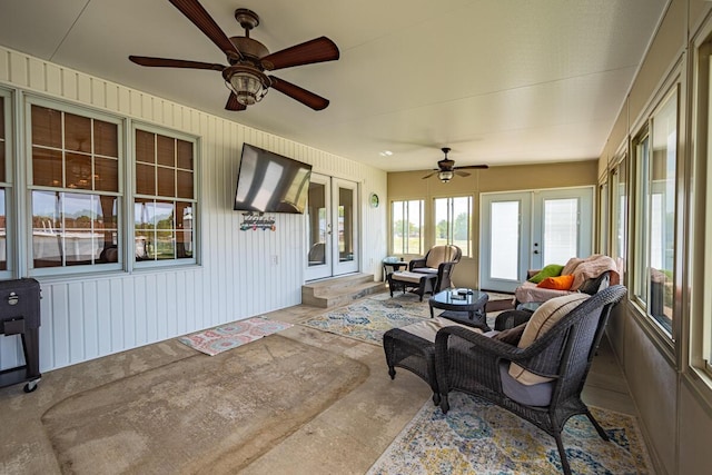 sunroom / solarium featuring ceiling fan and french doors