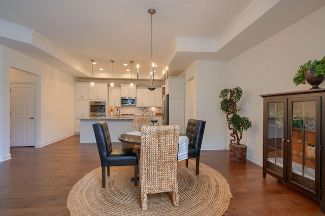 dining area featuring dark hardwood / wood-style floors, a raised ceiling, and ornamental molding