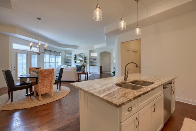 kitchen featuring a center island with sink, sink, and hanging light fixtures