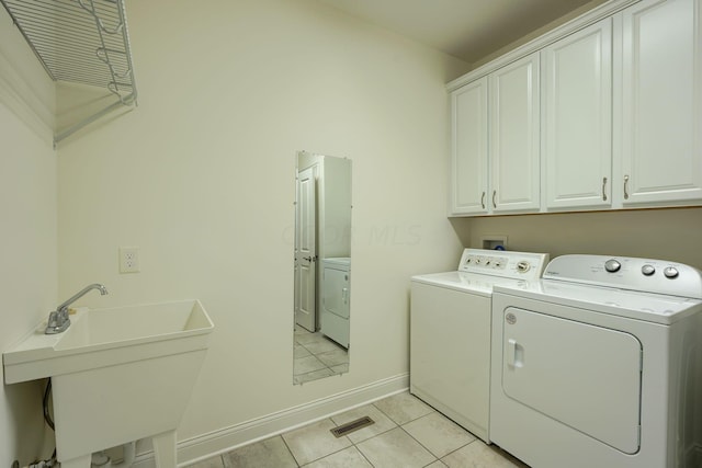 washroom with washer and dryer, cabinets, light tile patterned floors, and sink