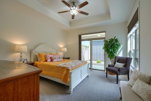 bedroom featuring ornamental molding, access to outside, a tray ceiling, ceiling fan, and light colored carpet