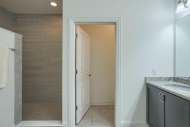 bathroom featuring tiled shower and vanity