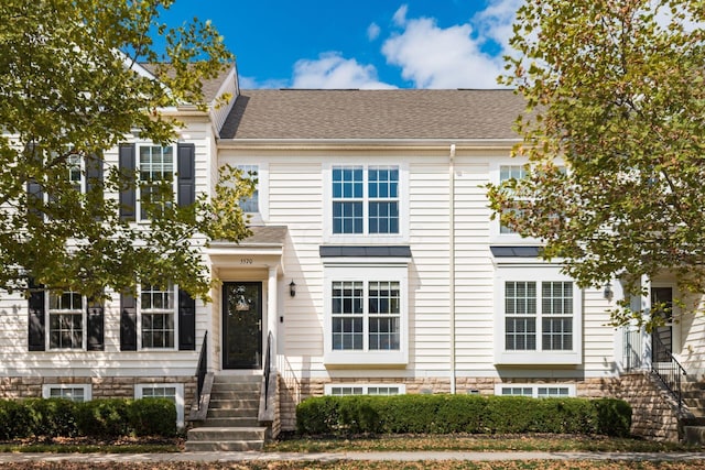 multi unit property with a shingled roof and entry steps