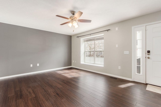 foyer entrance featuring baseboards, visible vents, ceiling fan, and dark wood-type flooring