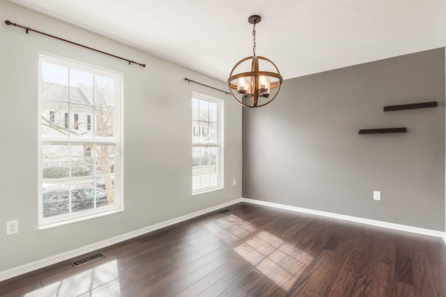 unfurnished room featuring a chandelier, visible vents, baseboards, and dark wood-style floors